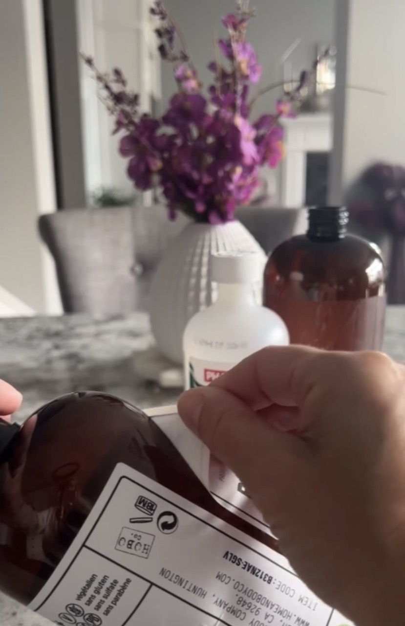 image of hand pealing off old bottle label