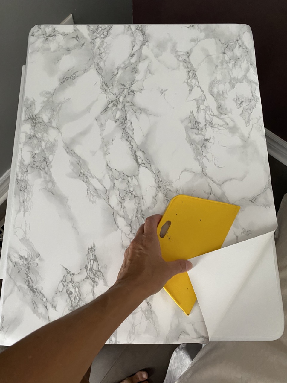 image of table in the process of applying adhesive marble film