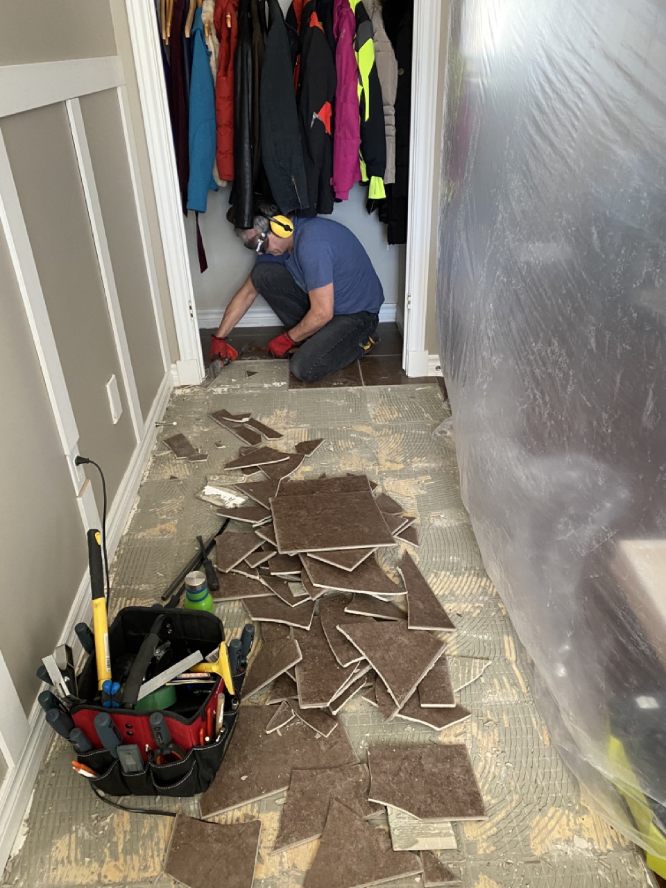 image of man removing brown tile floor