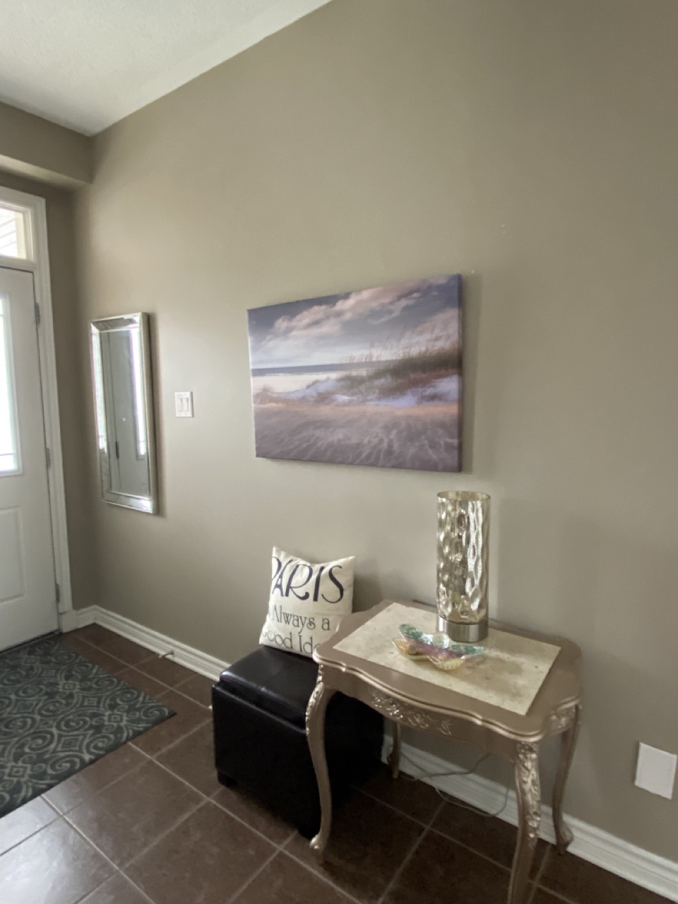 image of front entry before with brown floor and small table