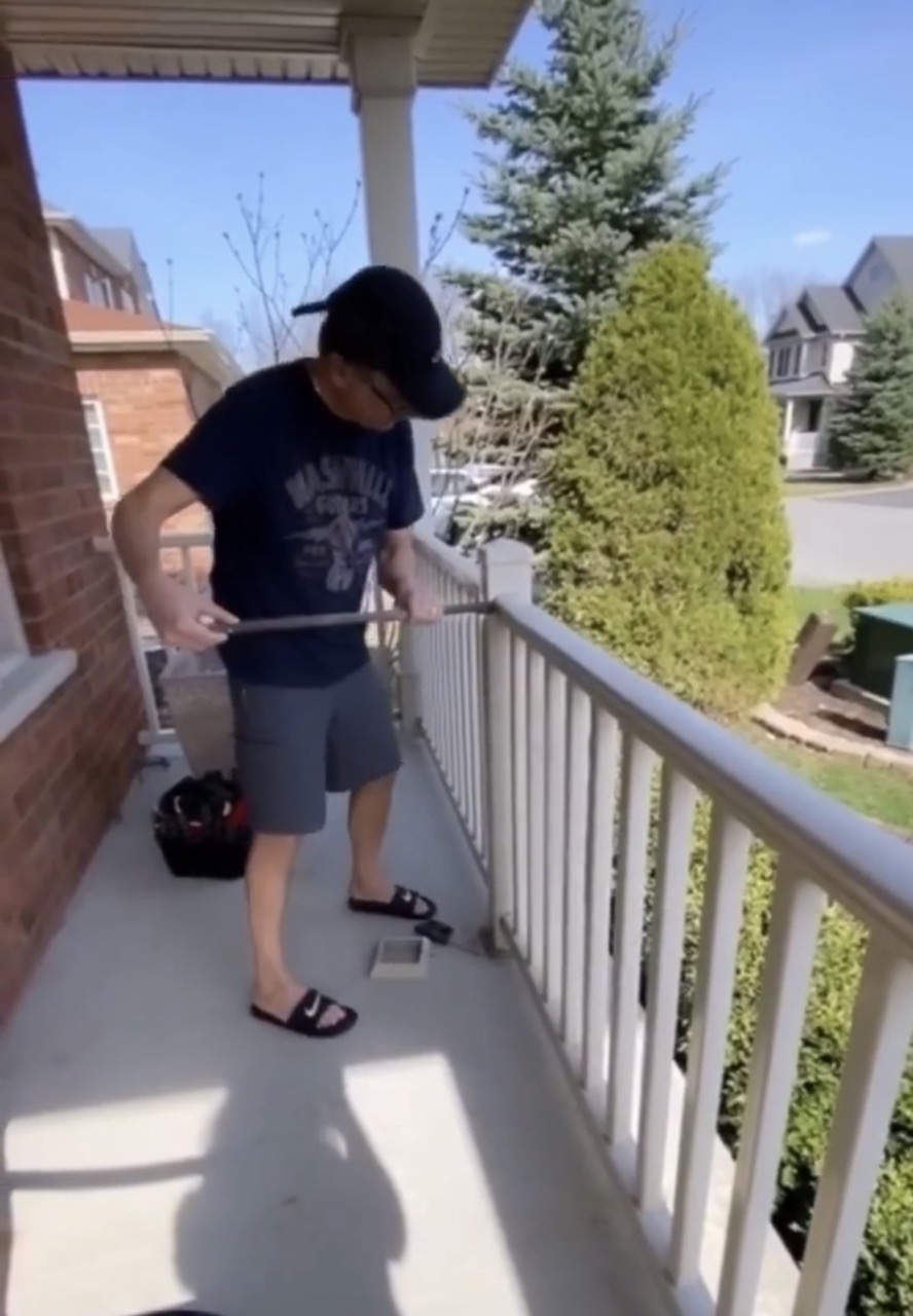 image of man prying off top of railing