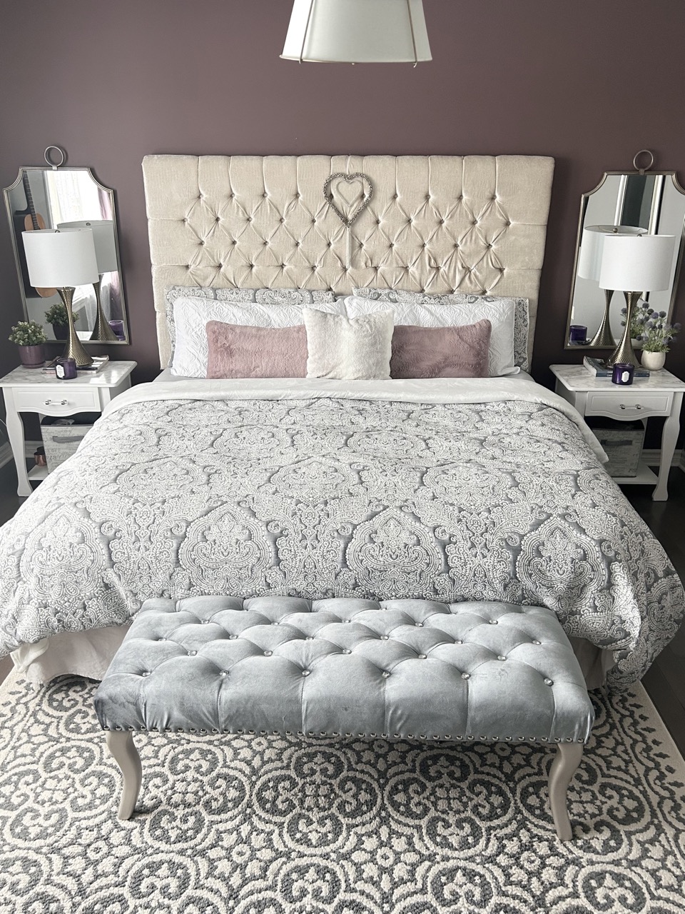 reveal image of moody romantic bedroom showing bed, tufted headboard and chandelier
