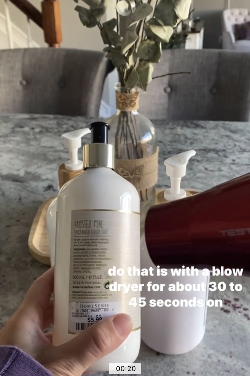 closeup image of blow dryer heating up old soap bottle label