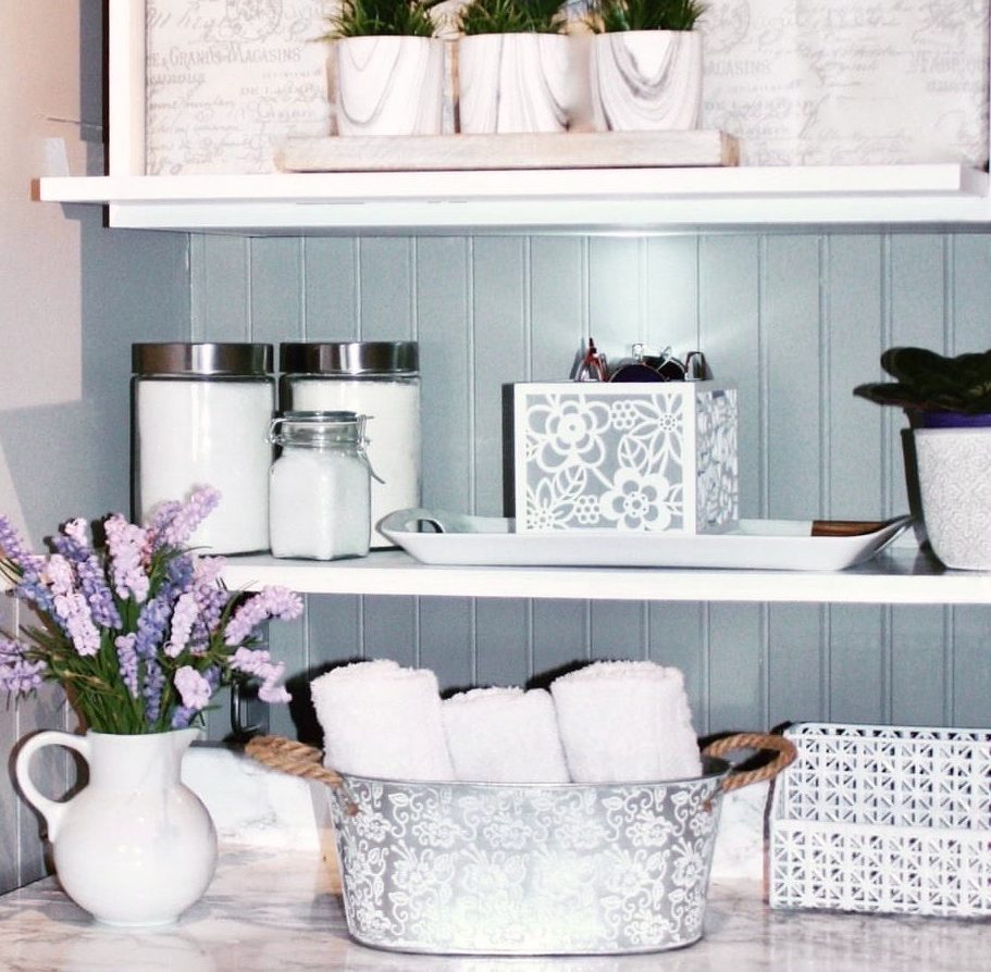 image of diy laundry room makeover showing decor including vase of flowers and basket of towels on the counter